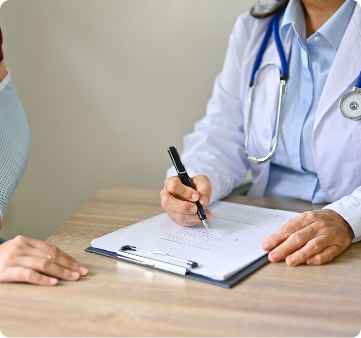 Un medico in camice bianco scrive appunti su una cartella clinica mentre un paziente, con il braccio fasciato, osserva la scena. 
